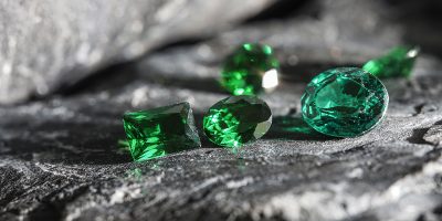 Glimmering natural green sapphire gemstones on a rugged rock surface The glimmering natural green sapphire gemstones on a rugged rock surface