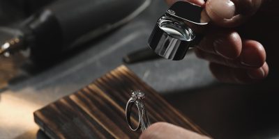 Professional jeweler working with ring at table, closeup Professional jeweler working with ring at table, closeup